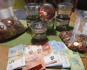 Erlös aus den Glücksgläsern 2019 Die leeren Glücksgläser und das darin enthaltene Kleingeld sowie mehrere Scheine.